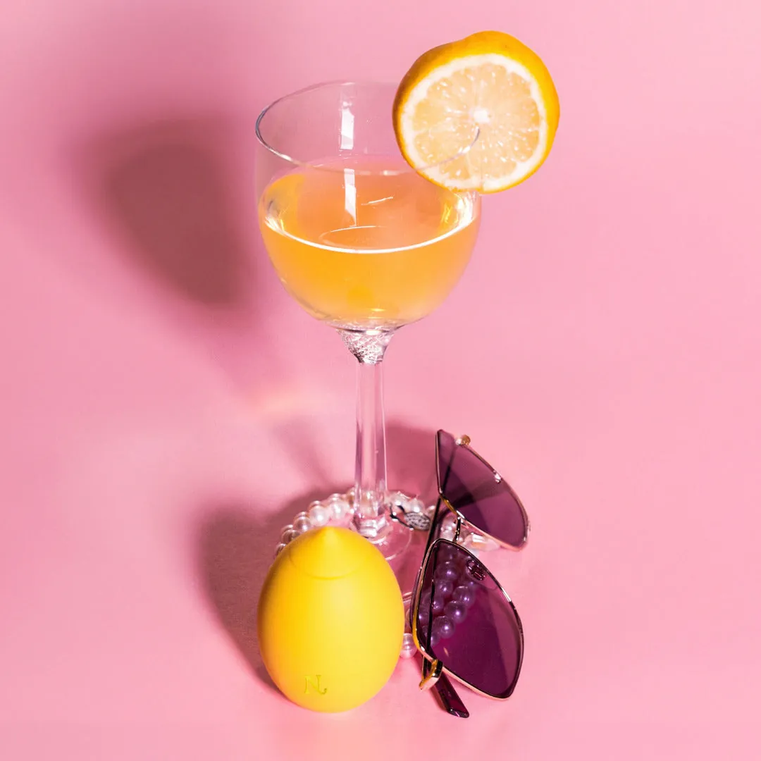Nancy Lem next to a glass of lemonade on a pink background